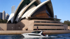 White motor cruiser passing the Sydney Opera House on Sydney Harbour